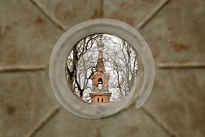 Glimpse of Divinity: Church Tower Through Metal Fence in Kuldiga, Latvija