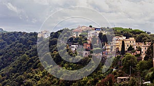 Glimpse of the lush hilly landscape and Castel Gandolfo village located at Lake Albano slopes in Italy