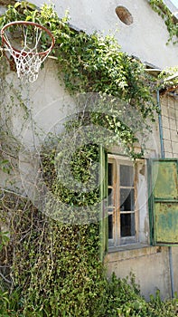 The glimpse of an old country house with an old basketball hoop on the wall