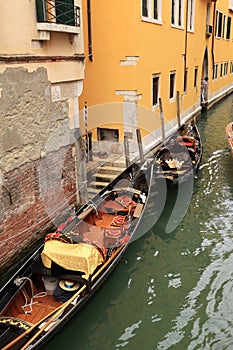 glimpse of one of the canals of Venice with poles tied to them