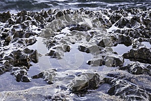 Glistening volcanic rocks on a beach