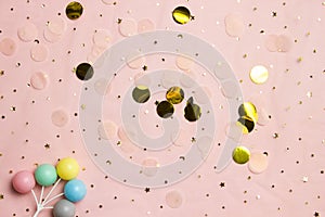 Glitter background with colorful balls. Golden stars in the form of confetti on pink background.