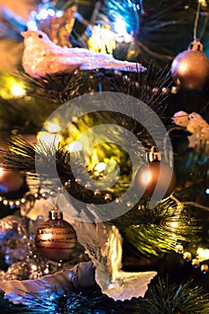 Glitter balls on Christmas tree among tree branches and other christmas decorations and lights