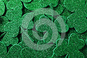 Glitter green clover leaves as background. St. Patrick`s Day celebration