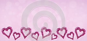 Glitter hearts with bokeh on pink background. Valentines day and love concept