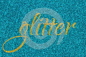 Glitter lettering word gold on cyan blue sparkle texture. Shiny background