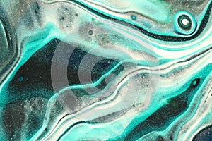 Glitter teal flows across the canvas with layers of black and white in this abstract background.