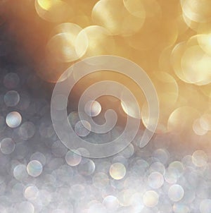 Glitter vintage lights background. light gold, silver and black. defocused.