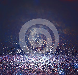 Glitter vintage lights background. light silver, purple, blue, gold and black. defocused.