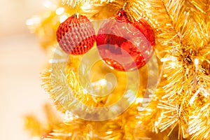 Glittering Baubles with Glowing Sparkling Gold defocused Light bokeh Illumination background with decorated Christmas Tree.