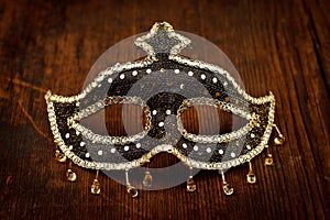 Glittering carnival mask on wooden table