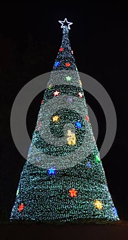 Glittering Glowing Sparkling defocused Night Light bokeh Illumination background with decorated Christmas Tree. Special Holidays