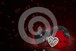 Glittering mirror disco ball and decorative hearts. Valentine`s Day. Holiday party. Entertainment, disco, music show background