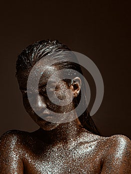 Glittering silver female body art , young beautiful naked girl with wet hair, skin in sparkles, studio beauty portrait