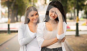 Gloating Girl Rejoicing At Misfortune Of Crying Female Friend Outdoors photo