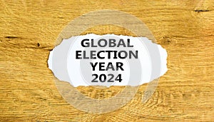 Global election year 2024 symbol. Concept words Global election year 2024 on beautiful white paper. Beautiful wooden background.