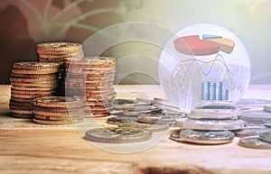 GLOBAL FINANCIAL CONCEPT. Stack of coins and globe with graph icons over a blur map background. Selective focus photo