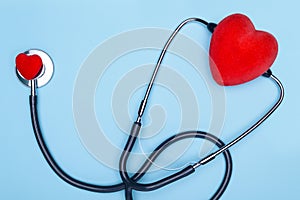 Global healthcare concept.Stylish doctor with heart on blue background.Close-up of red heart and stethoscope on a blue background.