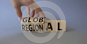 Global and Local symbol. Businessman hand turnes wooden cubes and changes word Local to Global. Beautiful grey background.
