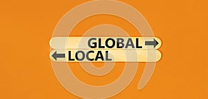 Global or local symbol. Concept word Global or Local on beautiful wooden stick. Beautiful orange table orange background. Business