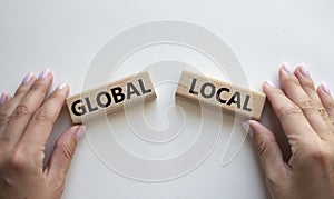 Global and Local symbol. Concept word Global and Local on wooden blocks. Businessman hand. Beautiful white background. Business