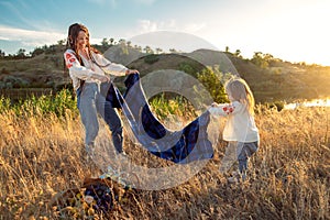 Global view, real life around the globe, local living. Mom and daughter in national clothes and flower wreaths are