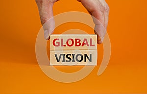 Global vision symbol. Wooden blocks with words `Global vision` on beautiful orange background. Businessman hand. Business and