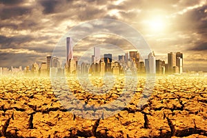 Global warming - dried up barren land and a city, photo