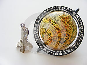 Globe and eiffel tower model on white background photo