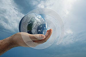 Globe in human hand against blue sky. Environmental protection concept.