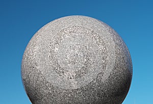 A globe made of granite under the blue sky