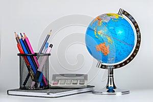 Globe, notebook stack and pencils. Accessories for schoolchildren and students. Back to the school concept.