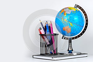 Globe, notebook stack and pencils. Accessories for schoolchildren and students. Back to the school concept.