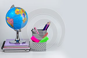 Globe, notebook stack and pencils. Accessories for schoolchildren and students. Back to the school concept.