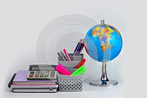 Globe, notebook stack and pencils. Accessories for schoolchildren and students. Back to the school concept.