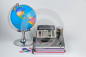 Globe, notebook stack and pencils. Accessories for schoolchildren and students. Back to the school concept.