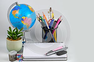 Globe, notebook stack and pencils. Accessories for schoolchildren and students. Back to the school concept.