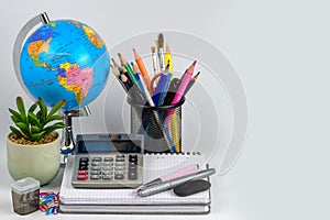 Globe, notebook stack and pencils. Accessories for schoolchildren and students. Back to the school concept.
