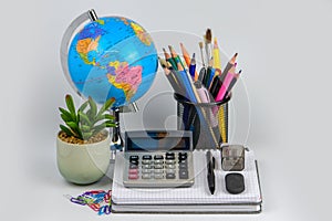 Globe, notebook stack and pencils. Accessories for schoolchildren and students. Back to the school concept.