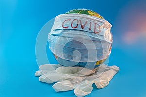 Globe of planet dressed a medical mask with text Covid -19 worldwide epidemic. Coronavirus planet pandemic concept