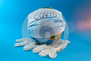 Globe of planet dressed a medical mask with text Covid -19 worldwide epidemic. Coronavirus planet pandemic concept