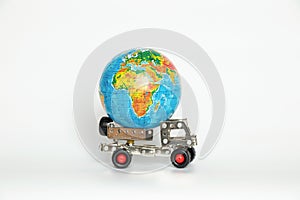 Globe on a small children's car on a white background, international transportation, logistics