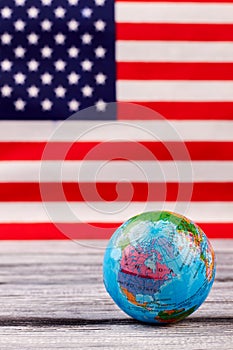 Globe on table with USA flag in the background.