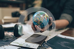 Globe, whole world in hands and compass, magnifying glass and book on route map on the table. Travel , Adventure and Discovery