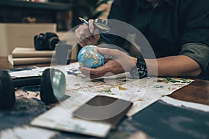 Globe, whole world in hands and compass, magnifying glass and book on route map on the table. Travel , Adventure and Discovery