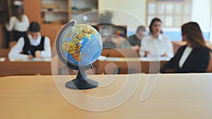 A globe of the world in a school classroom during a lesson.