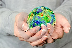 The globe is in your hands. The whole world is in your hands. A young girl holds the planet Earth in her hands. World environment 
