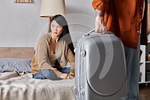 gloomy asian woman sitting on bed