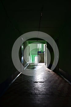 The gloomy corridor of a neglected public building. Public space in a poor residential high-rise buildin