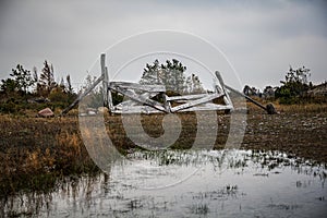 Gloomy landscape with old broken wood fence and marsh
